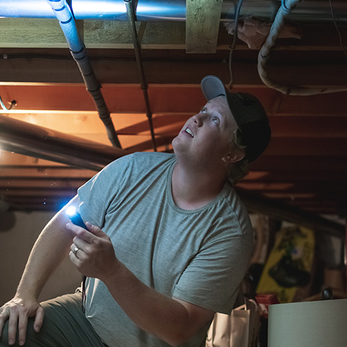 Nathan inspecting the heating and cooling system during a home inspection.